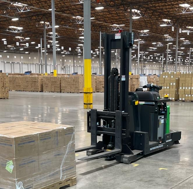 Photo of a robotic forklift about to pick up a pallet of boxes