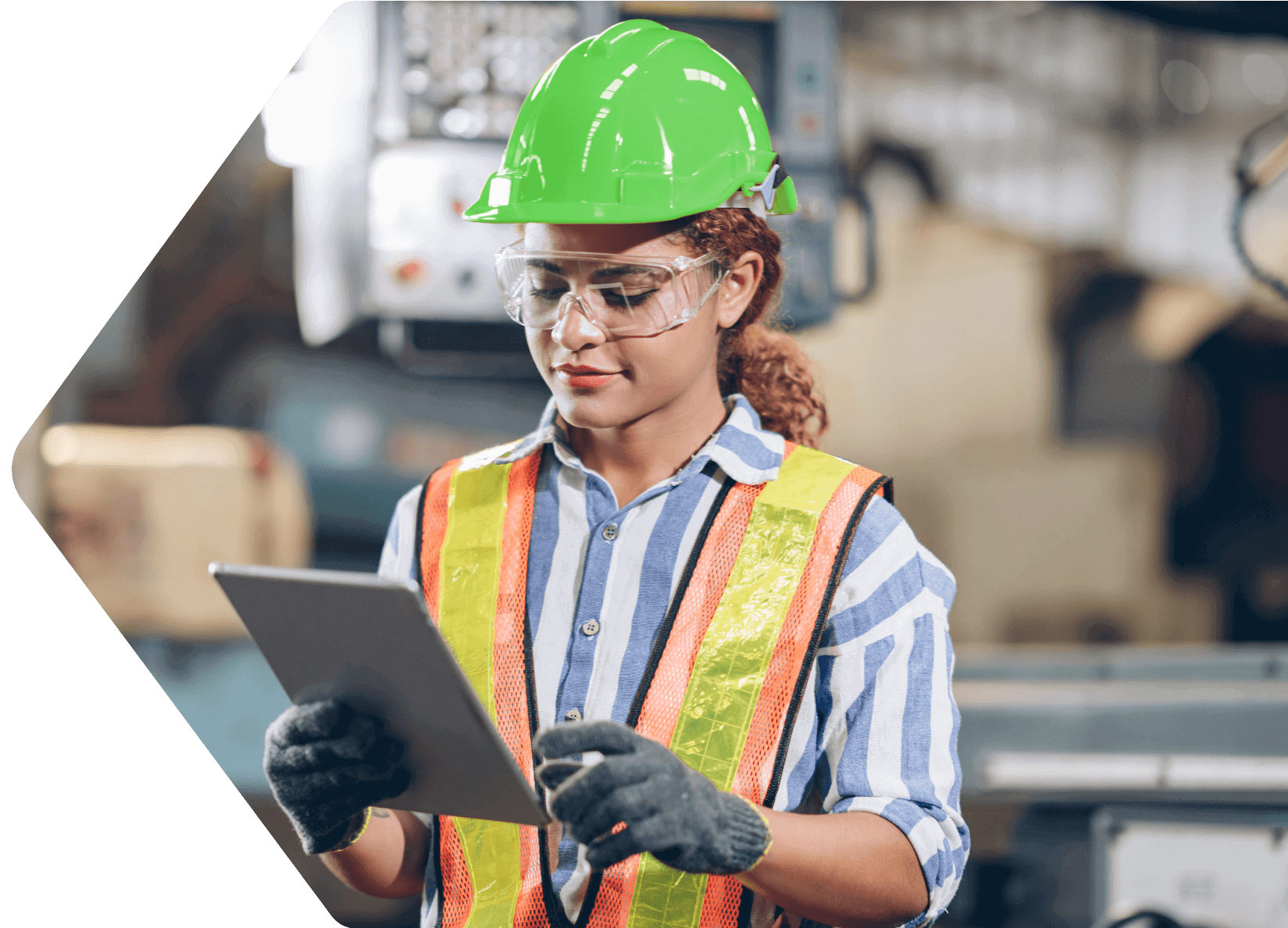 photo of a woman in a green hard hat and holding a tablet